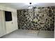 Versatile room featuring a stylish stone accent wall, neutral paint and access to the door at 6264 Godfrey Sw Dr, Mableton, GA 30126