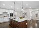 Bright kitchen features a large island with granite countertops, stainless steel appliances and modern lighting fixtures at 942 Mclinden Se Ave, Smyrna, GA 30080