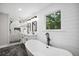 Modern bathroom featuring a soaking tub, a double vanity and a tiled shower with a glass door at 942 Mclinden Se Ave, Smyrna, GA 30080