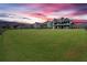Expansive backyard ideal for recreation, framed by a wooden fence and a picturesque sunset at 101 River Walk Pkwy, Euharlee, GA 30145