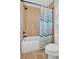 Bathroom features a shower with a striped curtain and travertine colored tile at 101 River Walk Pkwy, Euharlee, GA 30145