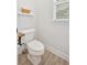 Half bath features a toilet, window and basket for storage at 101 River Walk Pkwy, Euharlee, GA 30145