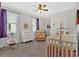Bedroom with a crib, glider, and changing table near a bright window at 101 River Walk Pkwy, Euharlee, GA 30145