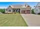 Charming home with a well-manicured lawn, stone accents, and a two-car garage with a basketball hoop at 101 River Walk Pkwy, Euharlee, GA 30145