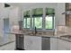 Modern kitchen featuring granite countertops, stainless steel appliances, and a large window overlooking the backyard at 101 River Walk Pkwy, Euharlee, GA 30145
