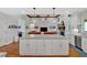 Open kitchen featuring a granite island with seating, hardwood floors, and stainless appliances at 101 River Walk Pkwy, Euharlee, GA 30145