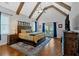 Spacious main bedroom featuring exposed beams, a ceiling fan, and access to a private balcony at 101 River Walk Pkwy, Euharlee, GA 30145