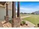 Inviting front porch with stone columns, a lush garden, and scenic neighborhood views at 101 River Walk Pkwy, Euharlee, GA 30145