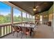 Charming screened porch with a dining table, stone fireplace, and views of the lush backyard at 101 River Walk Pkwy, Euharlee, GA 30145