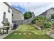 A grassy backyard with a retaining wall, some stone pavers, and several mature plantings at 1767 Weatherbrook Cir, Lawrenceville, GA 30043