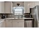 Well-lit kitchen features modern appliances, white cabinets, and sleek granite countertops at 1767 Weatherbrook Cir, Lawrenceville, GA 30043