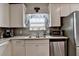 Well-lit kitchen features modern appliances, white cabinets, and sleek granite countertops at 1767 Weatherbrook Cir, Lawrenceville, GA 30043
