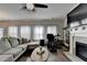Comfortable living room showcasing a gray sofa, fireplace, dark hardwood floors, and lots of natural light at 1767 Weatherbrook Cir, Lawrenceville, GA 30043