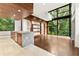 Open kitchen with wood paneled ceilings, stone island, and floor to ceiling windows looking out to lush greenery at 2105 Fairhaven Ne Cir, Atlanta, GA 30305