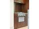 Close up of stainless steel range top and oven set amongst wood cabinetry and stone counter at 2105 Fairhaven Ne Cir, Atlanta, GA 30305