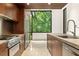 Modern kitchen with stainless steel appliances, stone counters, and large windows with natural views at 2105 Fairhaven Ne Cir, Atlanta, GA 30305