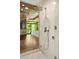 Close-up of large walk-in shower with rainfall shower head and wood ceiling and green outdoor view at 2105 Fairhaven Ne Cir, Atlanta, GA 30305