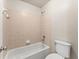 Bathroom featuring a tub with tile surround, a shower head, and a toilet at 2345 Gallard St, Lawrenceville, GA 30043