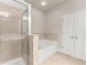 Bathroom featuring glass shower, a tub with tile surround and a double door closet at 2345 Gallard St, Lawrenceville, GA 30043
