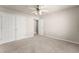 A carpeted bedroom with neutral walls, ceiling fan, closet, and access to another room at 2345 Gallard St, Lawrenceville, GA 30043