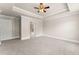 Large bedroom featuring tray ceiling, ceiling fan, neutral paint, and carpet flooring at 2345 Gallard St, Lawrenceville, GA 30043