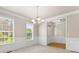 Bright dining area with hardwood floors, chandelier, wainscoting, and a view to the front door at 2345 Gallard St, Lawrenceville, GA 30043