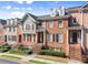 Brick townhomes featuring steps to entryways and small manicured bushes and trees at 2345 Gallard St, Lawrenceville, GA 30043