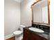 Elegant powder room featuring ornate mirror and a vanity with dark countertop at 2345 Gallard St, Lawrenceville, GA 30043