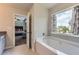 Bright bathroom with a soaking tub and a window overlooking the neighborhood at 2486 Bear Mountain St, Lithonia, GA 30058