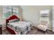 Comfortable bedroom with a red headboard, chair, and natural light at 2486 Bear Mountain St, Lithonia, GA 30058