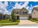 Two-story home featuring a well-maintained lawn, a two-car garage, and complemented by lush landscaping at 2486 Bear Mountain St, Lithonia, GA 30058