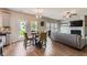 Open-concept dining and living area featuring wood floors, abundant light, and fireplace with white trim at 2486 Bear Mountain St, Lithonia, GA 30058