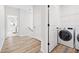 Bright laundry room with modern washer and dryer, plus convenient storage and wooden floor at 6710 Pippin Walk, Alpharetta, GA 30005