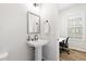 Stylish powder room with a pedestal sink and direct access to the home office at 6710 Pippin Walk, Alpharetta, GA 30005