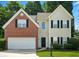 Charming two-story home with brick and siding exterior, an attached garage, and manicured landscaping at 5487 Walnut Lane Ln, Stonecrest, GA 30038
