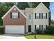 Charming two-story home with brick and siding exterior, an attached garage, and manicured landscaping at 5487 Walnut Lane Ln, Stonecrest, GA 30038