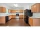 Spacious kitchen featuring stainless steel appliances, wooden cabinets, and dark wood flooring at 5487 Walnut Lane Ln, Stonecrest, GA 30038