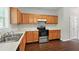 Traditional kitchen featuring wood cabinets, stainless steel appliances, and durable hardwood floors at 5487 Walnut Lane Ln, Stonecrest, GA 30038