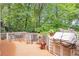 Outdoor back deck, perfect for outdoor relaxation with a BBQ grill and wooded views at 5600 Buck Hollow Dr, Alpharetta, GA 30005