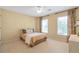 Bedroom with neutral walls, two windows, patterned drapes, and tan bedding at 5600 Buck Hollow Dr, Alpharetta, GA 30005