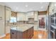 Gourmet kitchen boasts an island, custom cabinetry, modern appliances, and hardwood flooring at 5600 Buck Hollow Dr, Alpharetta, GA 30005