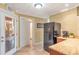Kitchenette in basement with cabinets, granite countertop, black refrigerator, and access to wine cellar at 5600 Buck Hollow Dr, Alpharetta, GA 30005