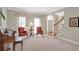 Comfortable living room featuring neutral carpeting, with large windows and staircase at 5600 Buck Hollow Dr, Alpharetta, GA 30005
