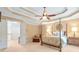 Spacious main bedroom with tray ceiling, fan, four-poster bed, sitting area and neutral walls at 5600 Buck Hollow Dr, Alpharetta, GA 30005