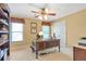 Well-lit office featuring built-in shelving, a wooden desk, and a neutral color palette with a ceiling fan at 5600 Buck Hollow Dr, Alpharetta, GA 30005