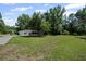 Well-maintained front yard with lush green grass, mature trees, and partial view of the house and driveway at 119 Walker Nw Rd, Cartersville, GA 30121