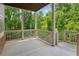 Outdoor porch with a concrete floor, wood railing and supports, and tree views at 328 Shade Tree Cir, Woodstock, GA 30188