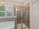 Elegant bathroom with a standalone shower, soaking tub, and decorative wall and floor tiles at 4814 Little Cove Ct, Auburn, GA 30011