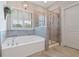 Elegant bathroom features a soaking tub, glass-enclosed shower, and elegant fixtures at 4814 Little Cove Ct, Auburn, GA 30011