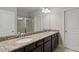 Granite-topped double vanity in a modern bathroom featuring tile floors and a glass-enclosed shower at 4814 Little Cove Ct, Auburn, GA 30011